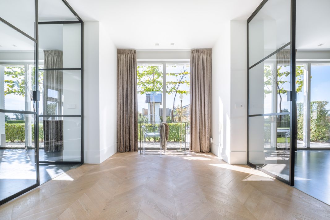 Wit strak interieur met stalen glasdeuren gemaakt door Wens&Co